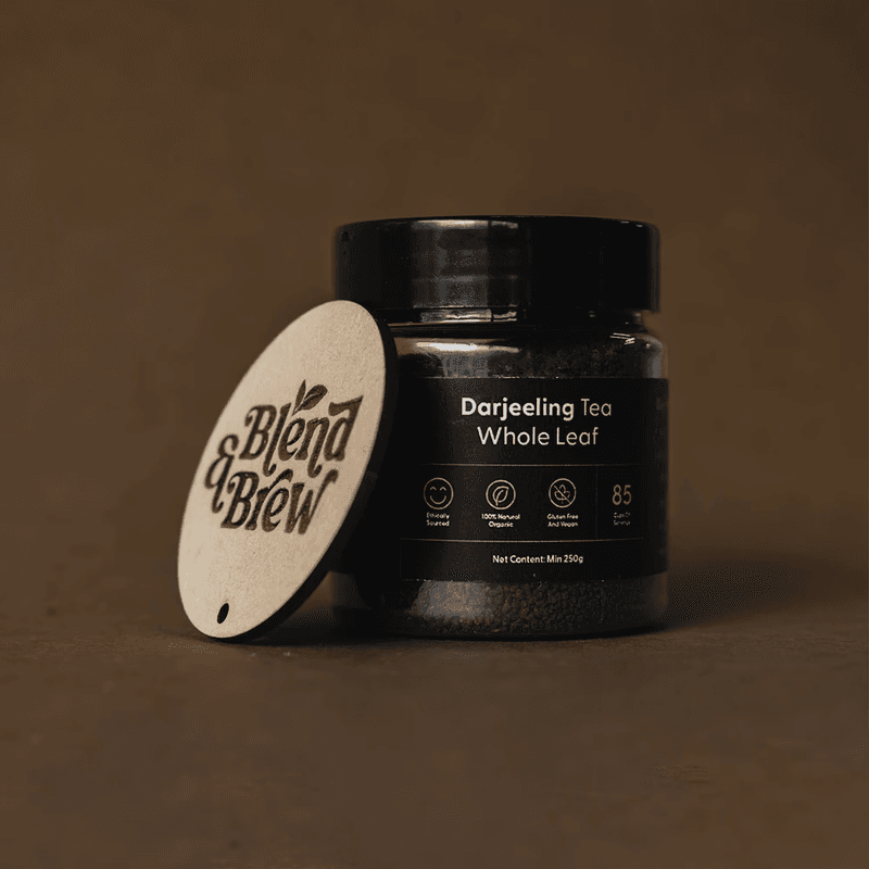 A jar of Darjeeling Whole Leaf tea with a branded wooden circular tag.